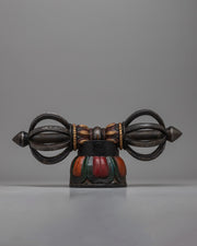The Tibetan Vajra on Wooden Stand is a stunning combination of traditional workmanship and artistic flair, precisely crafted from iron and painted with acrylic.