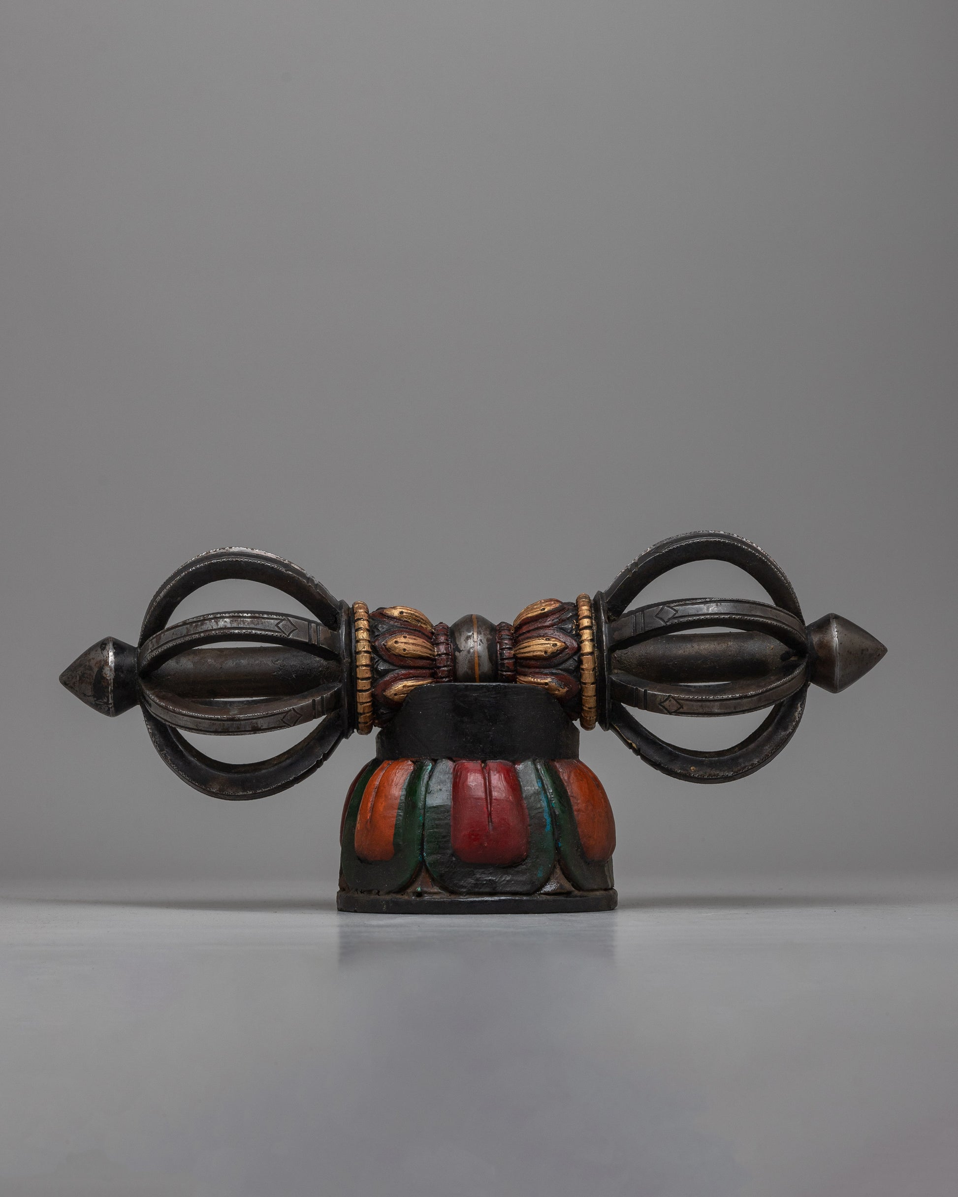 The Tibetan Vajra on Wooden Stand is a stunning combination of traditional workmanship and artistic flair, precisely crafted from iron and painted with acrylic.