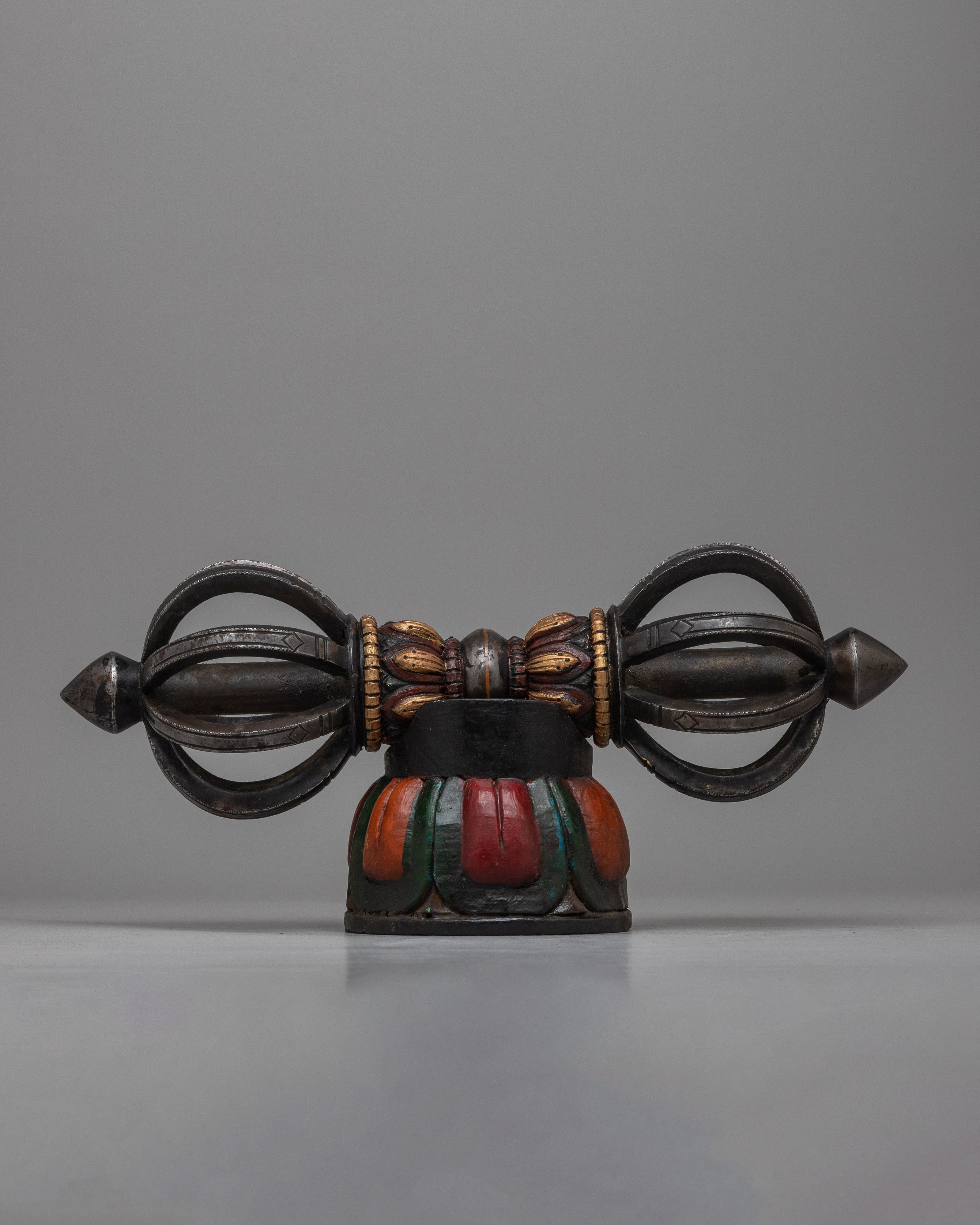 The Tibetan Vajra on Wooden Stand is a stunning combination of traditional workmanship and artistic flair, precisely crafted from iron and painted with acrylic.